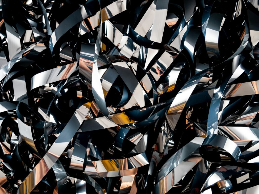 Dynamic close-up of metallic ribbons showcasing abstract art and reflective patterns.
