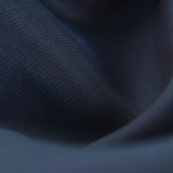 Detailed close-up of woven blue fabric with elegant crumples, highlighting texture and depth.
