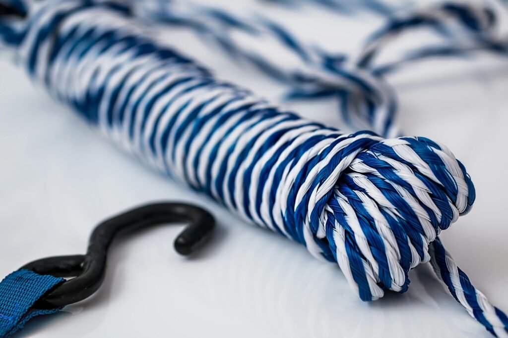 Detailed image of a blue and white rope, coiled with a metal hook.